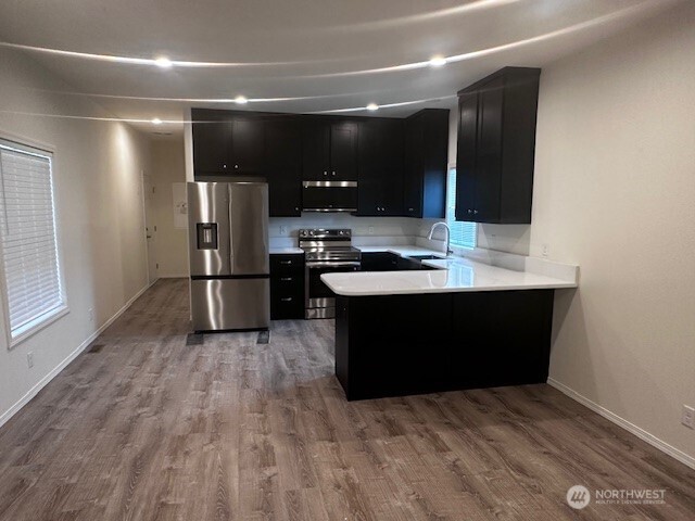 2101 South 324th Street, Unit 188 Federal Way, WA 98003 - Photo 3 of 10 a kitchen with kitchen island stainless steel appliances a sink cabinets and wooden floor