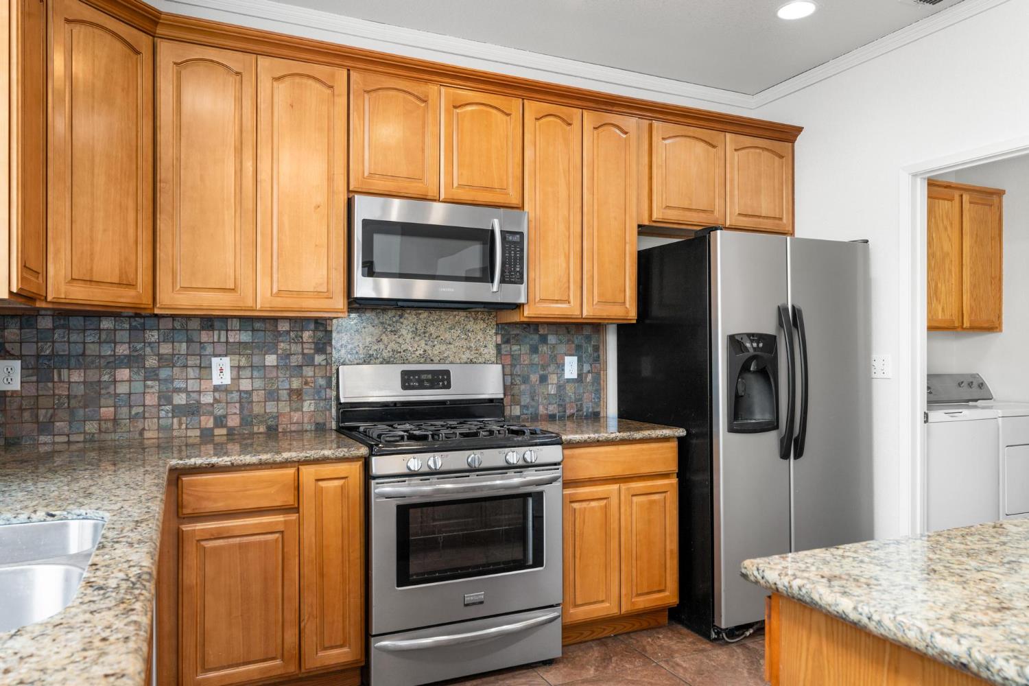 1833 Rail Street Manteca, CA 95337 - Photo 12 of 40 a kitchen with stainless steel appliances granite countertop a refrigerator stove and microwave