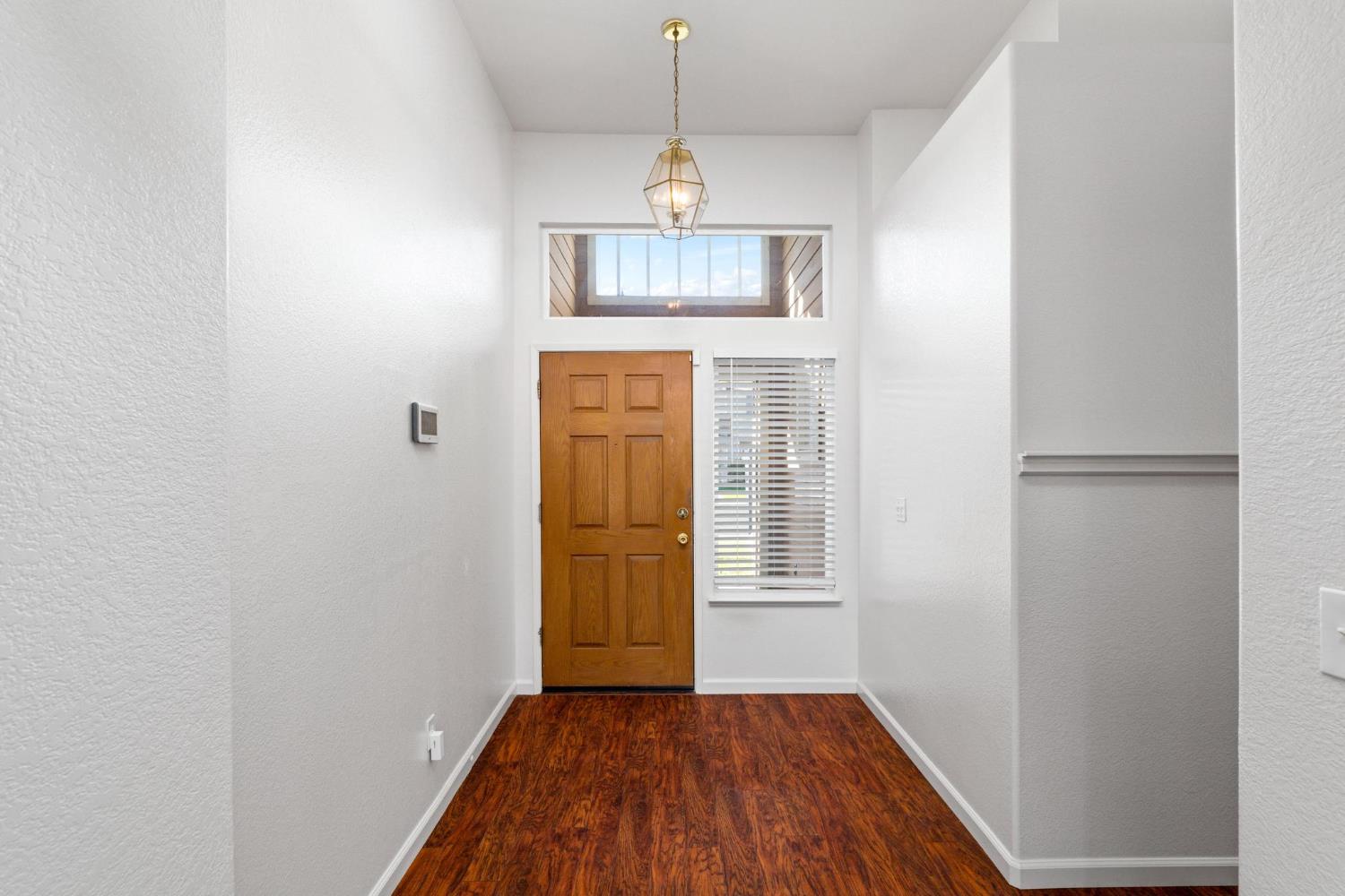 1833 Rail Street Manteca, CA 95337 - Photo 6 of 40 an entryway of a house with wooden floor a ceiling fan and windows