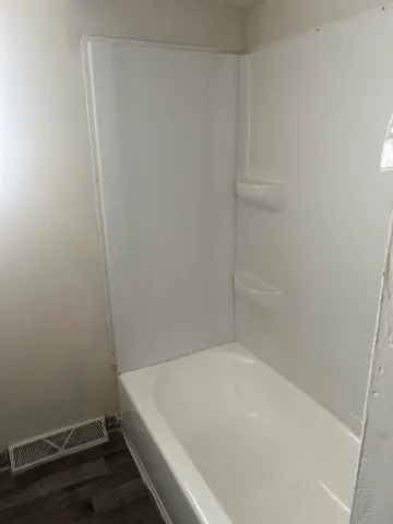 a view of a room with wooden floors and white walls