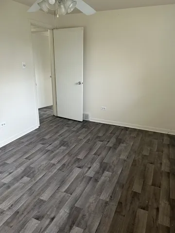 an empty room with wooden floor and a window