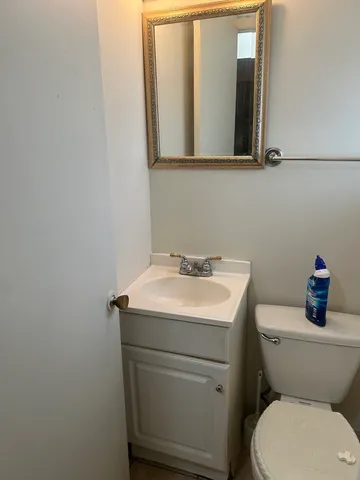 a bathroom with a toilet sink and mirror