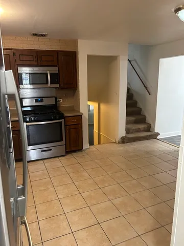 a kitchen with stainless steel appliances granite countertop a stove a refrigerator and a sink