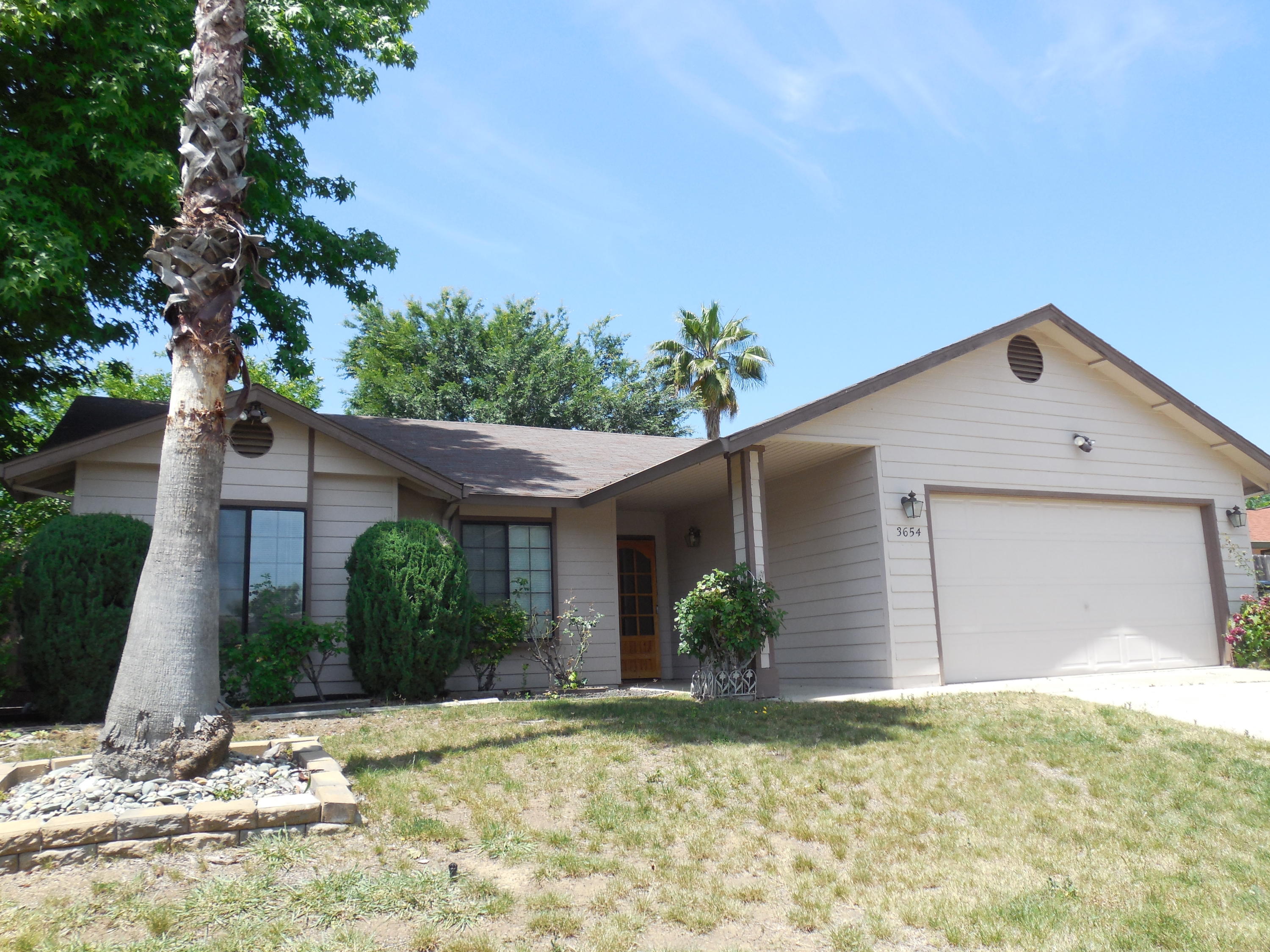3654 Santa Rosa Way Redding, CA 96003 - Photo 2 of 16 a front view of a house with a yard and garage