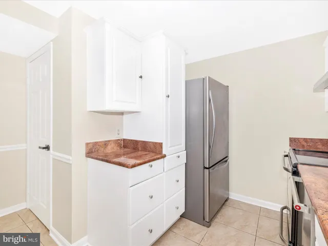 a kitchen with stainless steel appliances white cabinets and a refrigerator