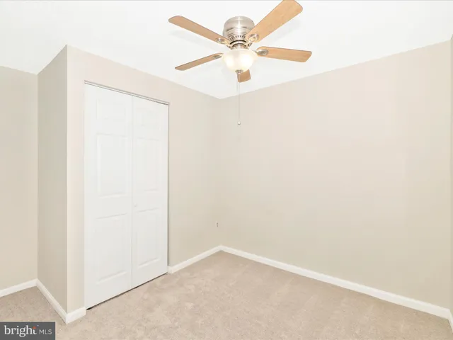 an empty room with a ceiling fan and a window