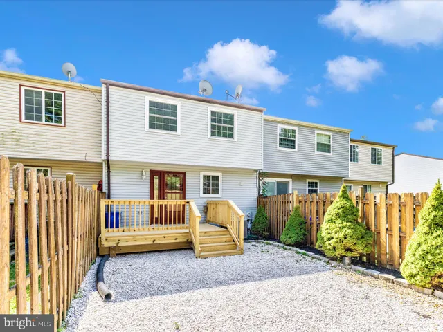 a view of a house with a small yard and wooden floor and fence