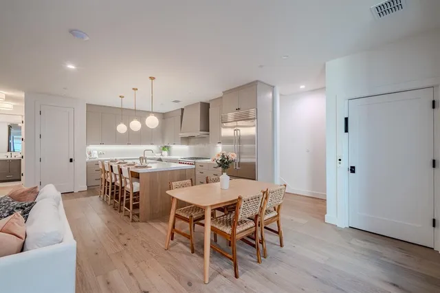 a living room with furniture a wooden floor and kitchen view