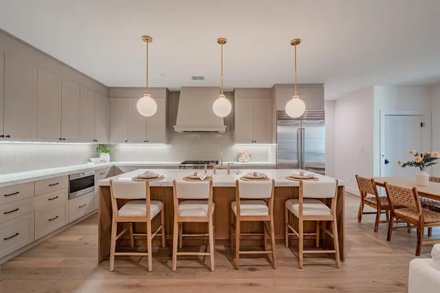 a kitchen with a dining table chairs and white cabinets