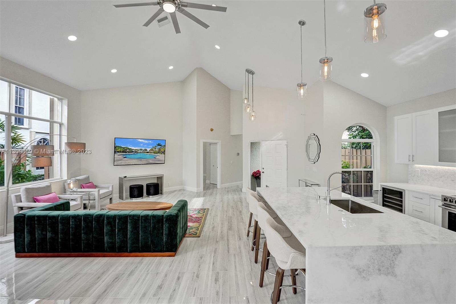 6688 Northwest 25th Court Boca Raton, FL 33496 - Photo 12 of 64 a living room with furniture a flat screen tv and a large window