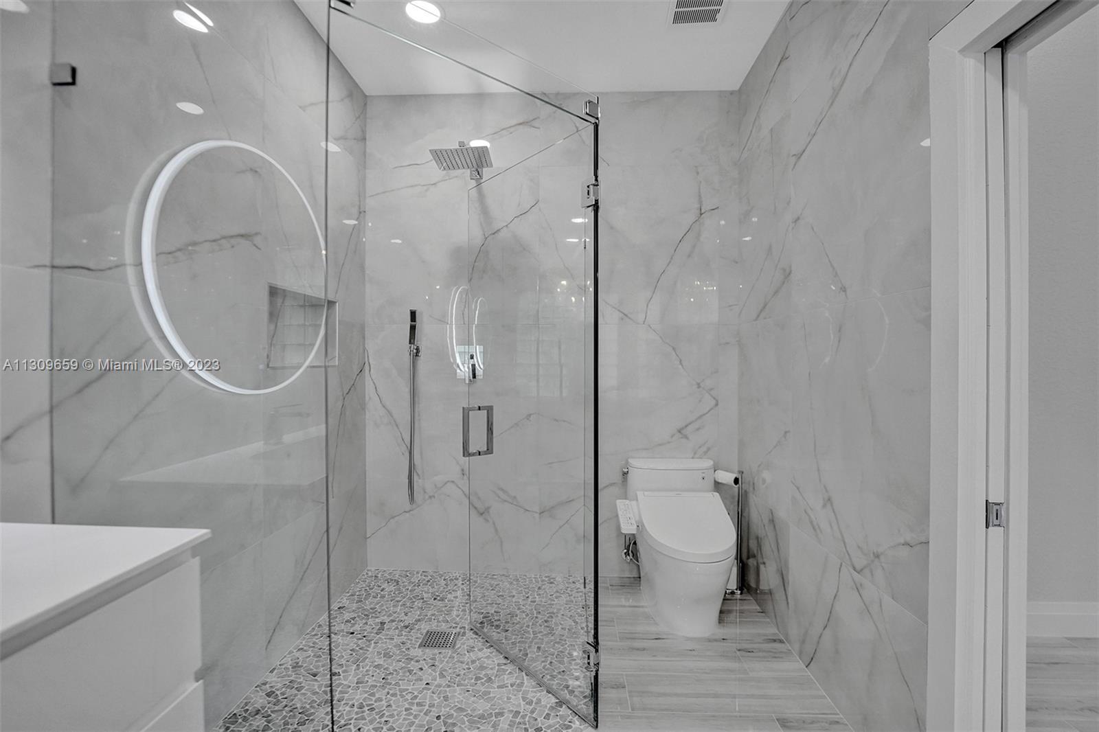 6688 Northwest 25th Court Boca Raton, FL 33496 - Photo 22 of 64 a bathroom with a glass shower door and a sink