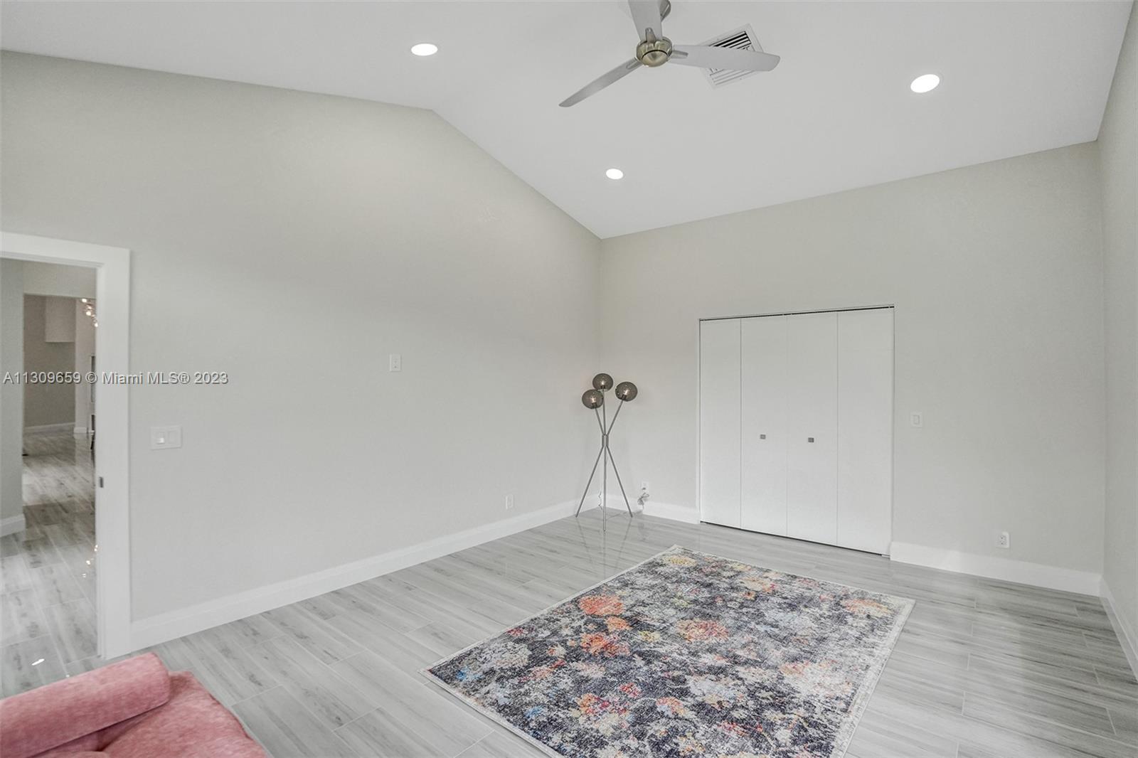 6688 Northwest 25th Court Boca Raton, FL 33496 - Photo 29 of 64 an empty room with wooden floor and a rug