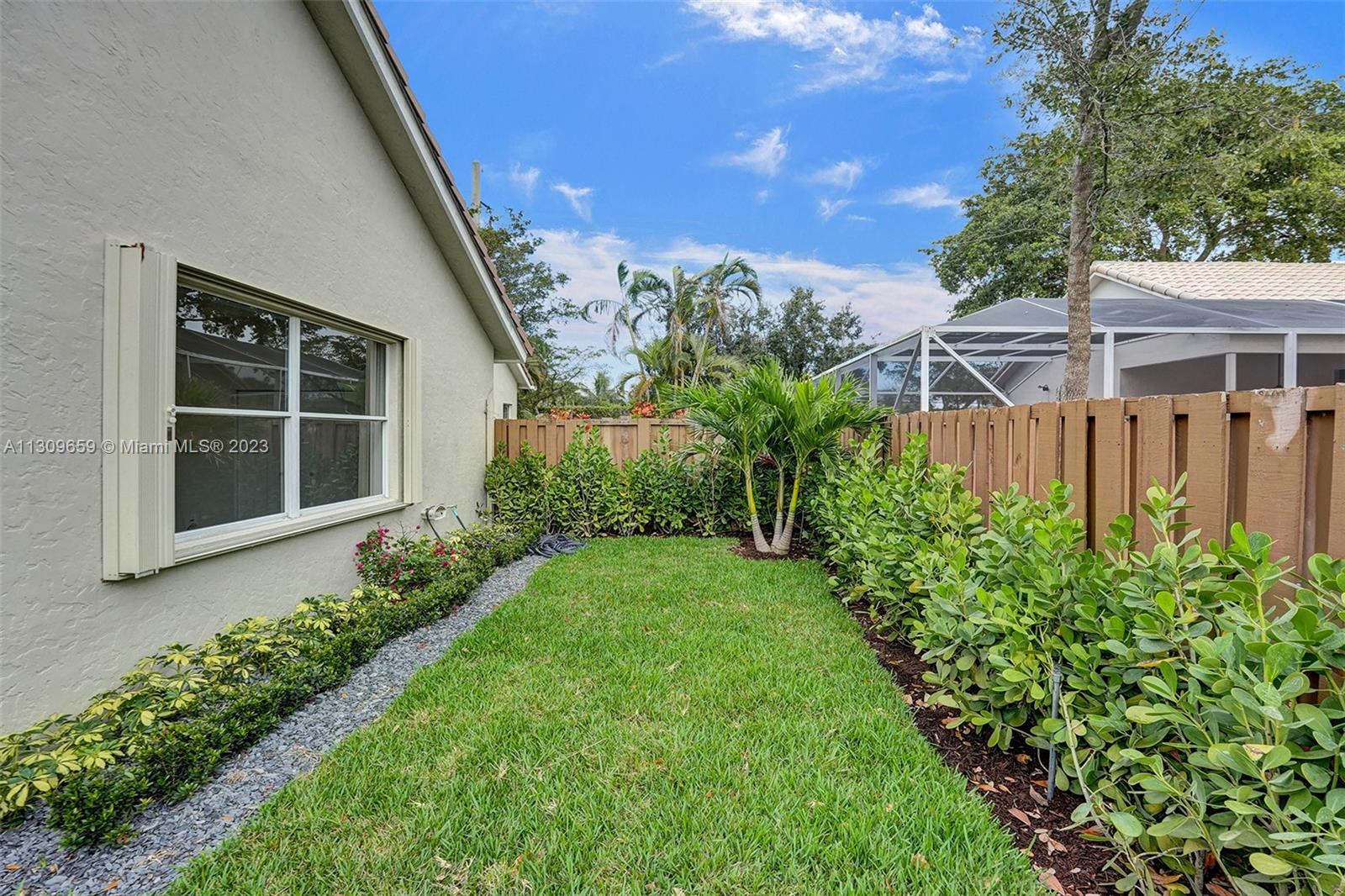 6688 Northwest 25th Court Boca Raton, FL 33496 - Photo 43 of 64 a view of a house with a flower garden