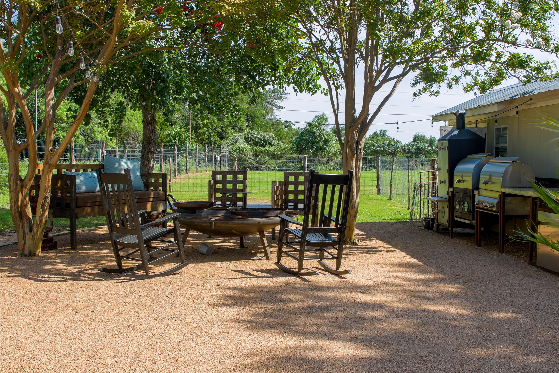 405 Frederick Road Fredericksburg, TX 78624 - Photo 18 of 29 Relax in the shade of mature trees, gathered around a large fire pit with ample seating for outdoor gatherings.