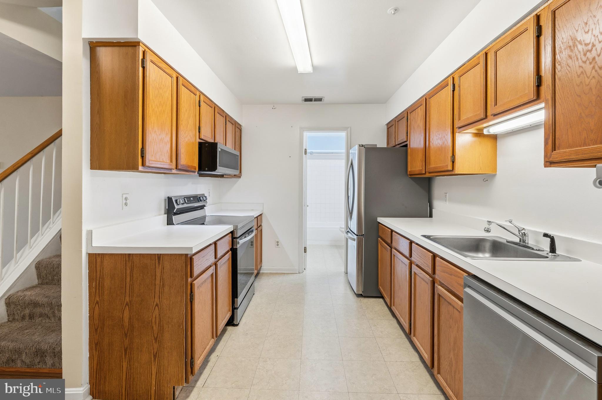2 Highstream Court, Unit 684 Germantown, MD 20874 - Photo 4 of 25 a kitchen with stainless steel appliances a sink a stove and a refrigerator