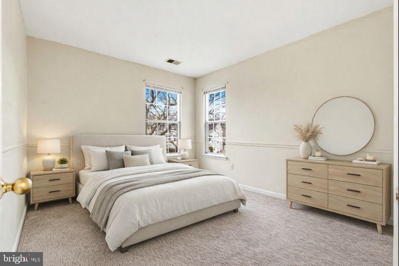 2 Highstream Court, Unit 684 Germantown, MD 20874 - Photo 7 of 25 a bedroom with a bed a dresser and a mirror