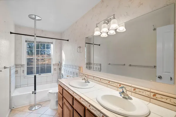 a bathroom with a tub a sink and a window
