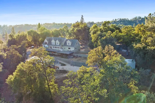 an aerial view of residential houses with outdoor space and ocean view