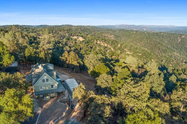 a view of a house next to a yard with road