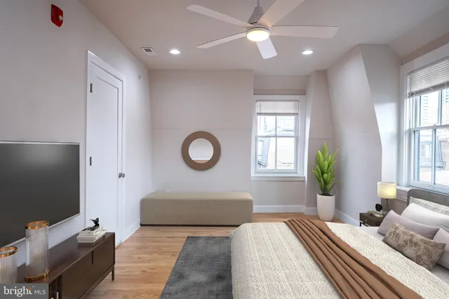 a bedroom with a bed and a flat tv screen on dresser