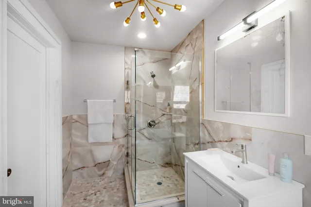 a bathroom with a sink mirror and shower
