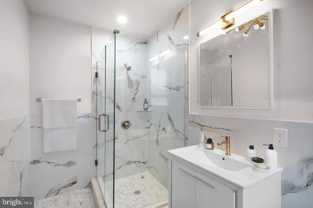 a bathroom with a sink vanity toilet and shower
