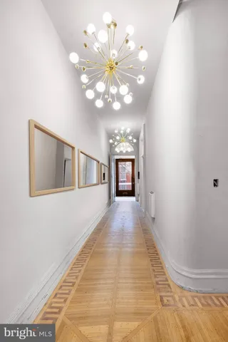 a view of a livingroom with a chandelier fan and windows