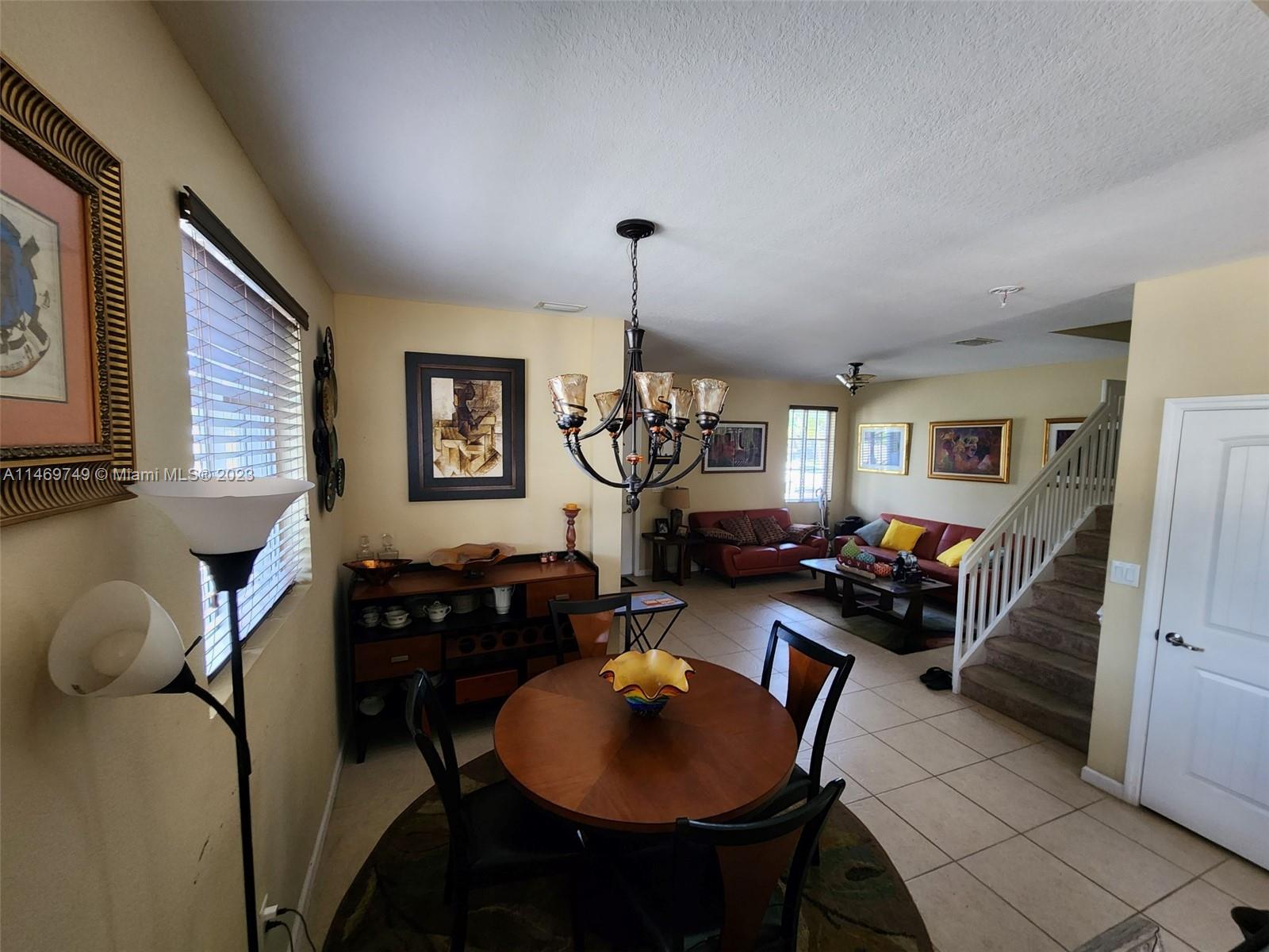 13986 Southwest 276th Street Homestead, FL 33032 - Photo 13 of 28 a living room with furniture a window and a chandelier