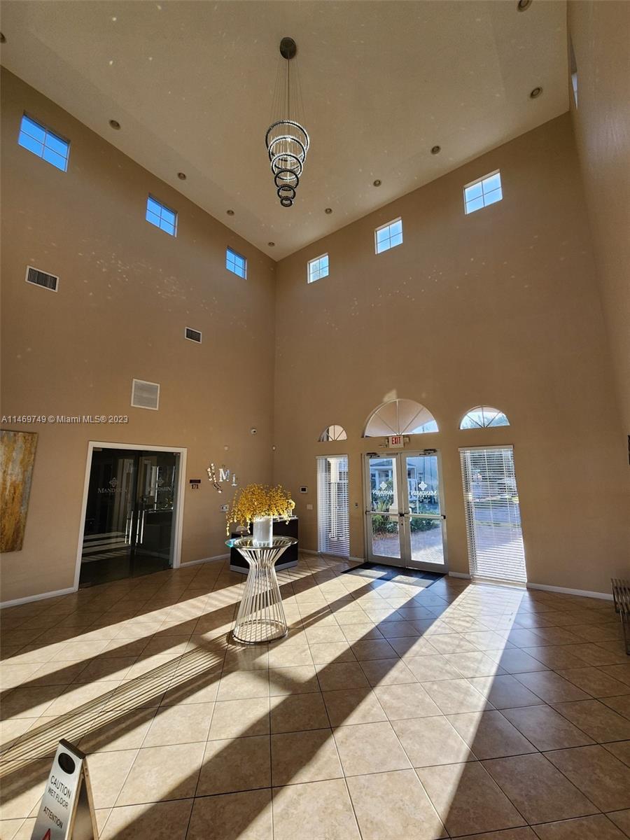 13986 Southwest 276th Street Homestead, FL 33032 - Photo 15 of 28 a lobby with a bed and a chandelier