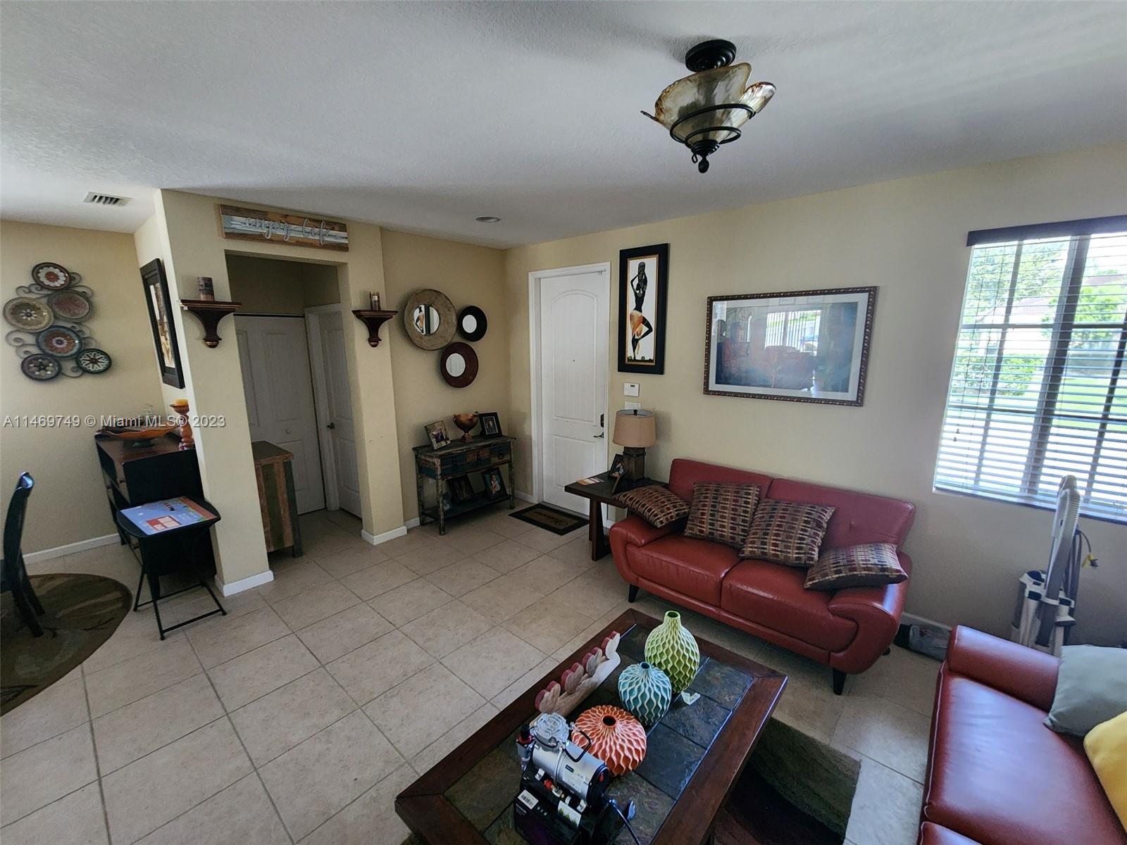 13986 Southwest 276th Street Homestead, FL 33032 - Photo 9 of 28 a living room with furniture a ceiling fan and a window