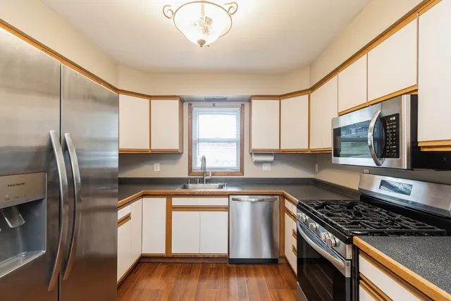 a kitchen with stainless steel appliances granite countertop a stove a sink and a refrigerator