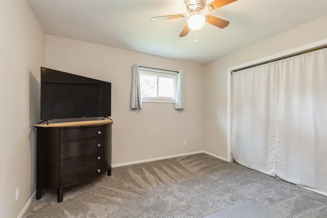 a view of an empty room with a flat screen tv and a window