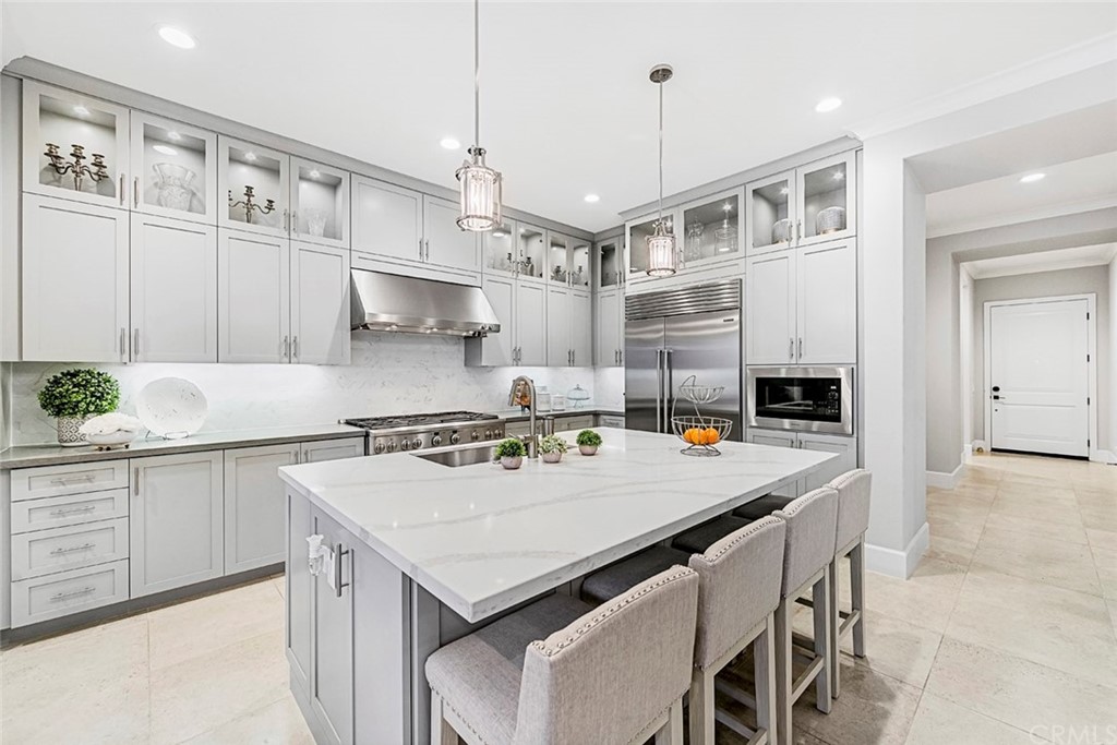 65 Rockinghorse Irvine, CA 92602 - Photo 14 of 51 a kitchen with a stove a chandelier and white cabinets