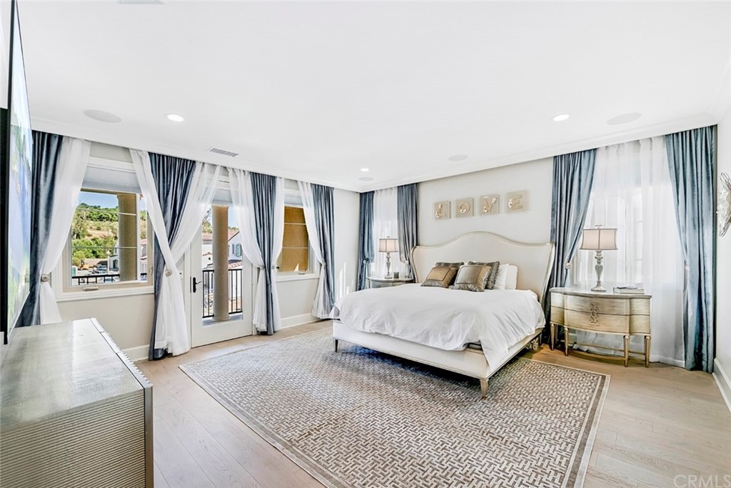 65 Rockinghorse Irvine, CA 92602 - Photo 22 of 51 a spacious bedroom with a large bed and a chandelier
