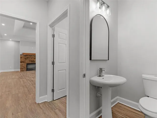 a bathroom with a sink a toilet and a mirror