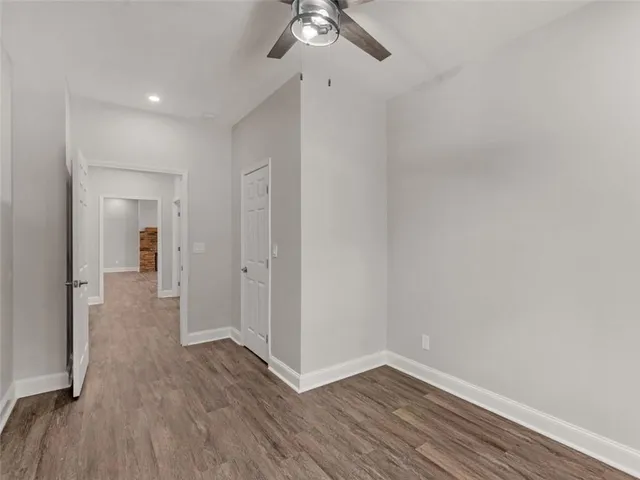 a view of a room with wooden floor and a ceiling fan