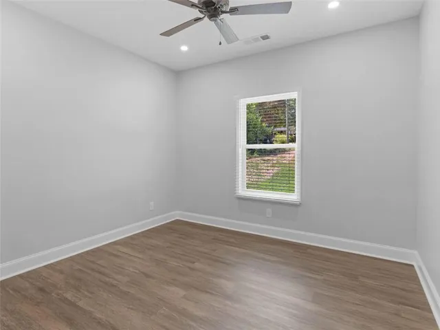 an empty room with a window and a ceiling fan