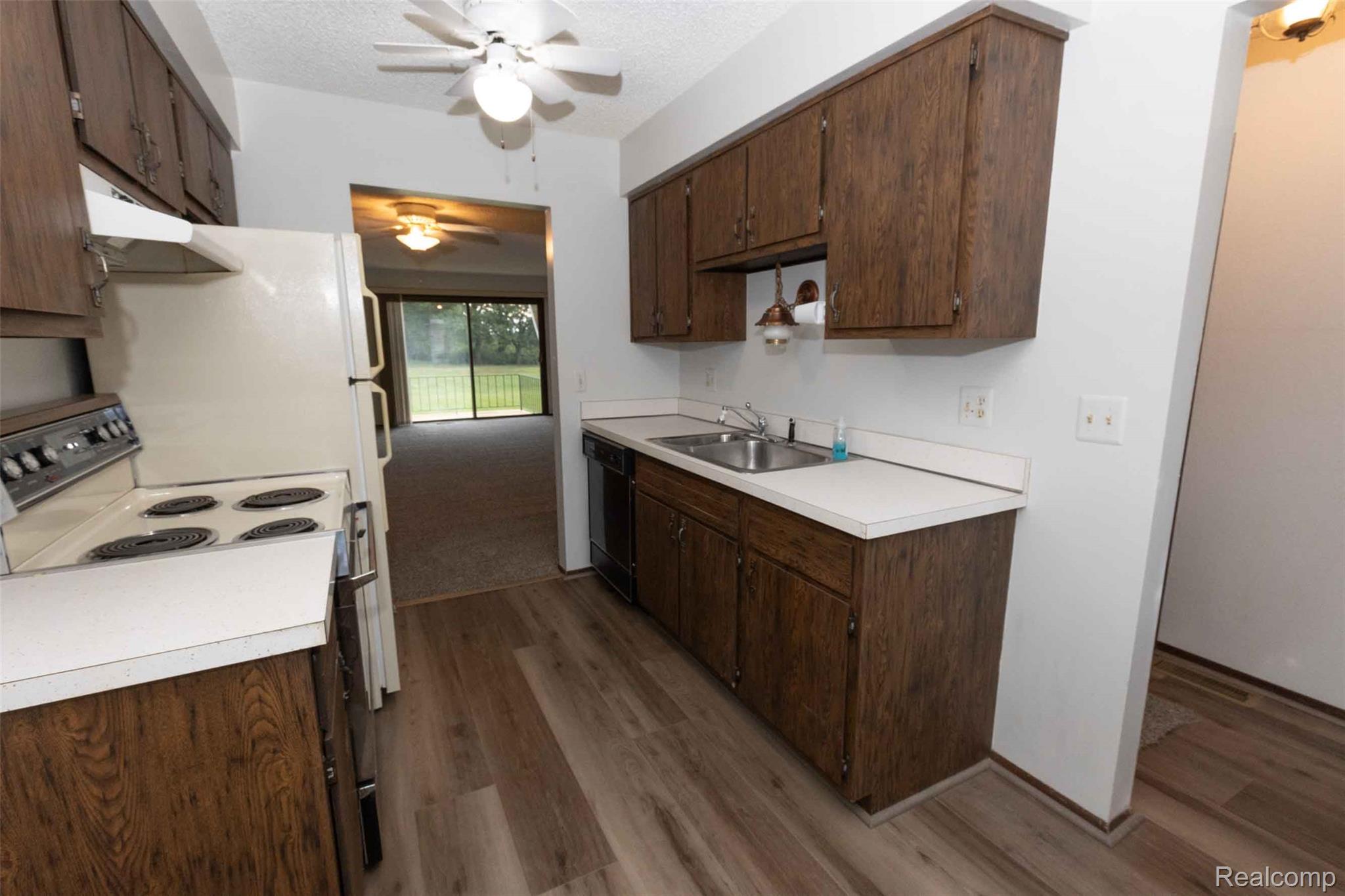 125 Cuttle Road Marysville, MI 48040 - Photo 8 of 44 Kitchen featuring wood-finish cabinetry, a stainless steel sink, white countertops, and wood-finish flooring