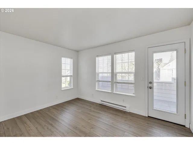 a view of an empty room with wooden floor