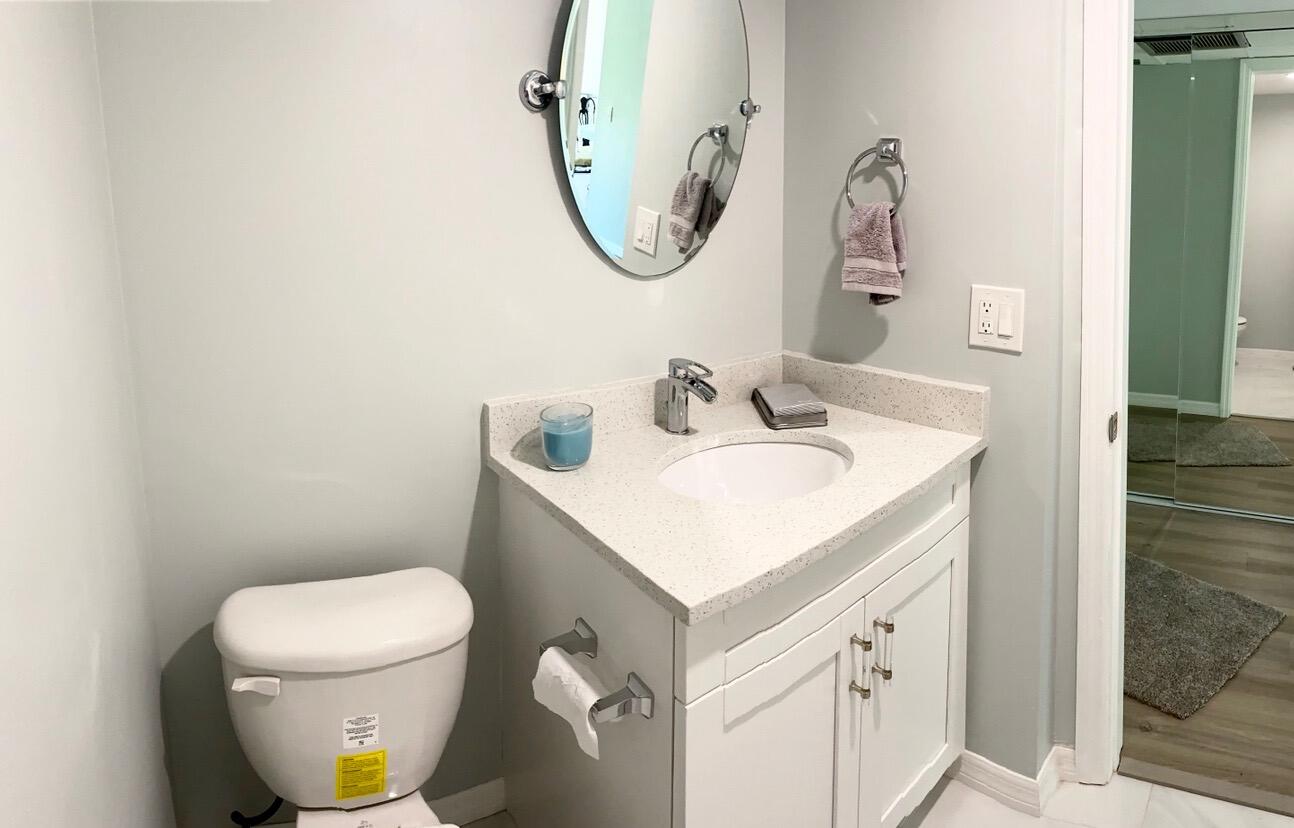 859 Jeffery Street, Unit 311 Boca Raton, FL 33487 - Photo 16 of 32 a bathroom with a sink toilet and a mirror