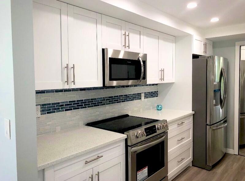 859 Jeffery Street, Unit 311 Boca Raton, FL 33487 - Photo 4 of 32 a kitchen with a stove microwave and refrigerator
