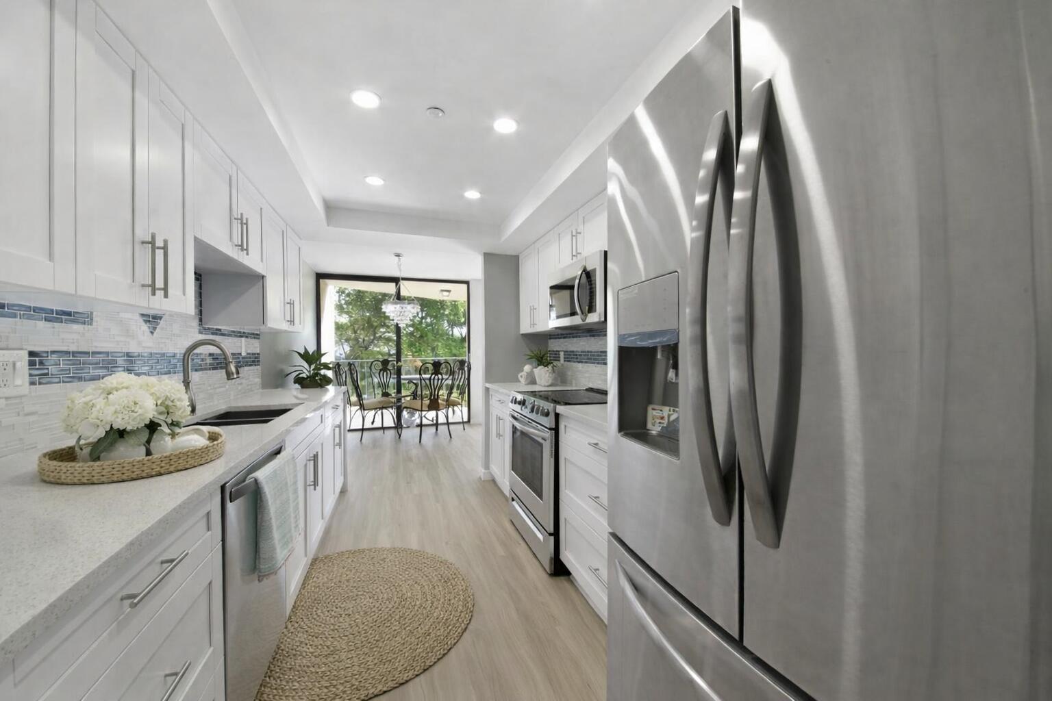 859 Jeffery Street, Unit 311 Boca Raton, FL 33487 - Photo 6 of 32 a kitchen with stainless steel appliances granite countertop a refrigerator a sink a stove and white cabinets