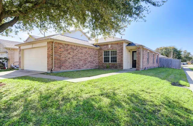 a view of a house with yard and a large tree