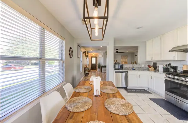 a open kitchen with stainless steel appliances granite countertop a stove a sink a dining table and chairs