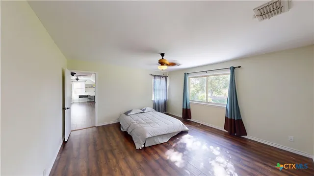 a bedroom with a bed and wooden floor