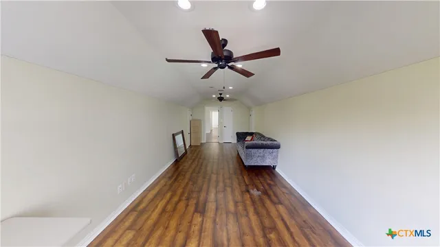 a view of a livingroom with wooden floor and a ceiling fan