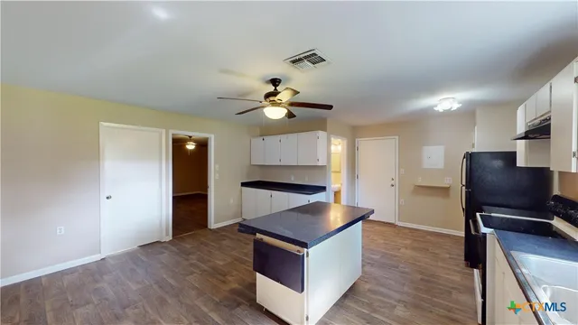 a living room with stainless steel appliances furniture and a flat screen tv