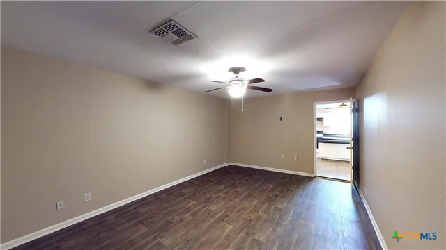 a view of empty room with wooden floor