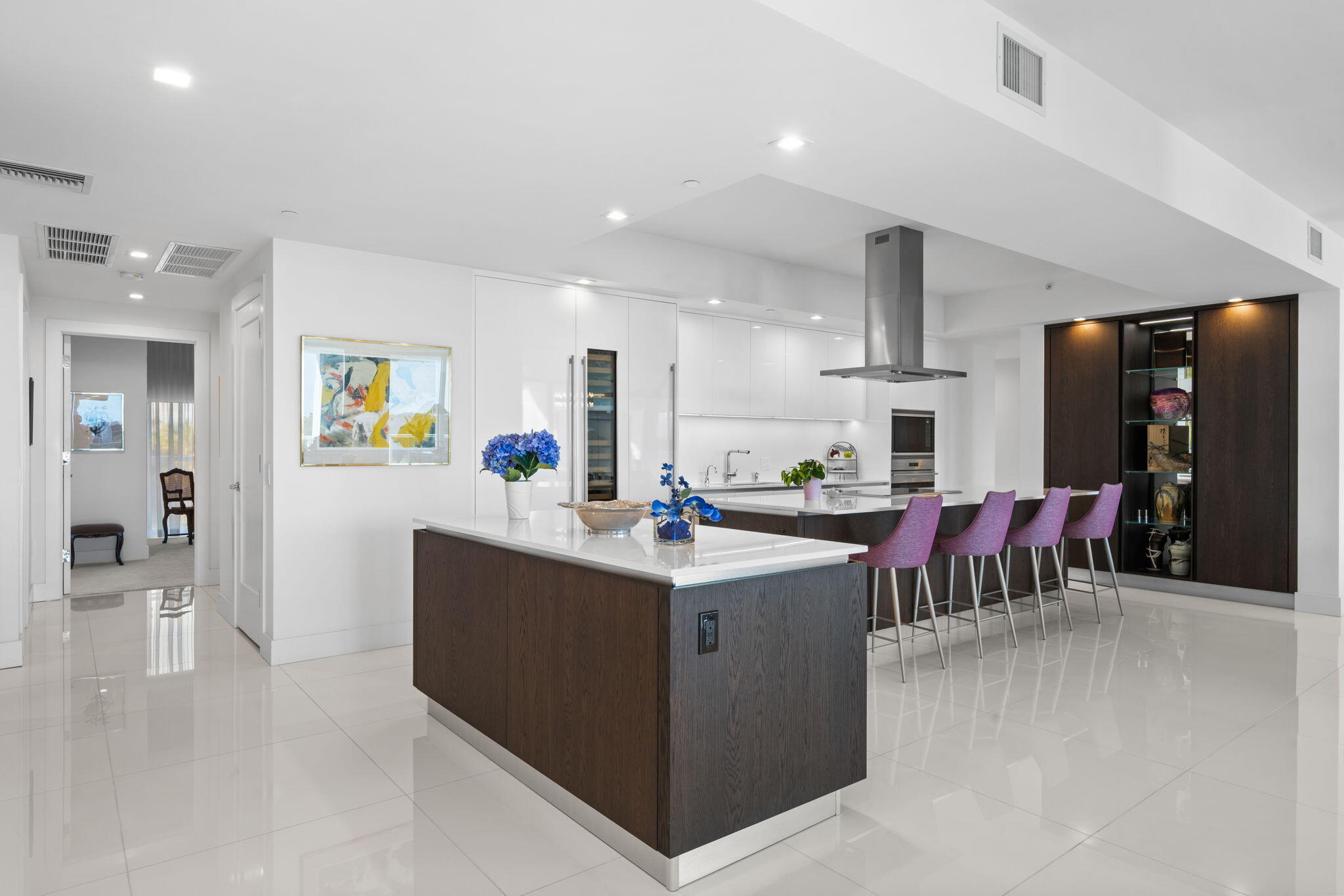a living room with stainless steel appliances kitchen island granite countertop a sink and a refrigerator