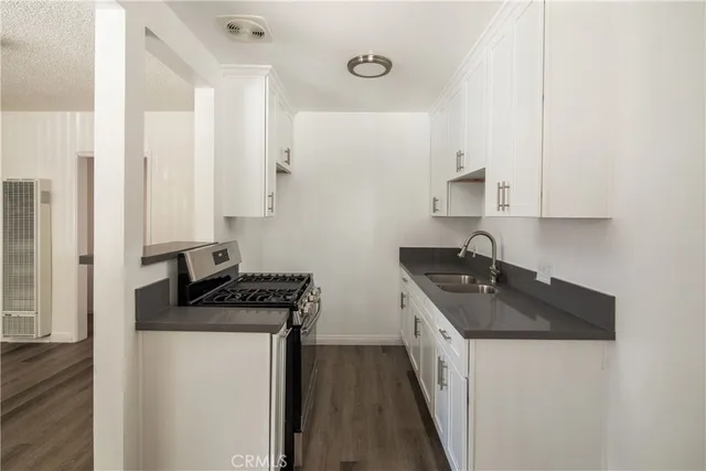 a kitchen with stainless steel appliances granite countertop a sink stove and cabinets
